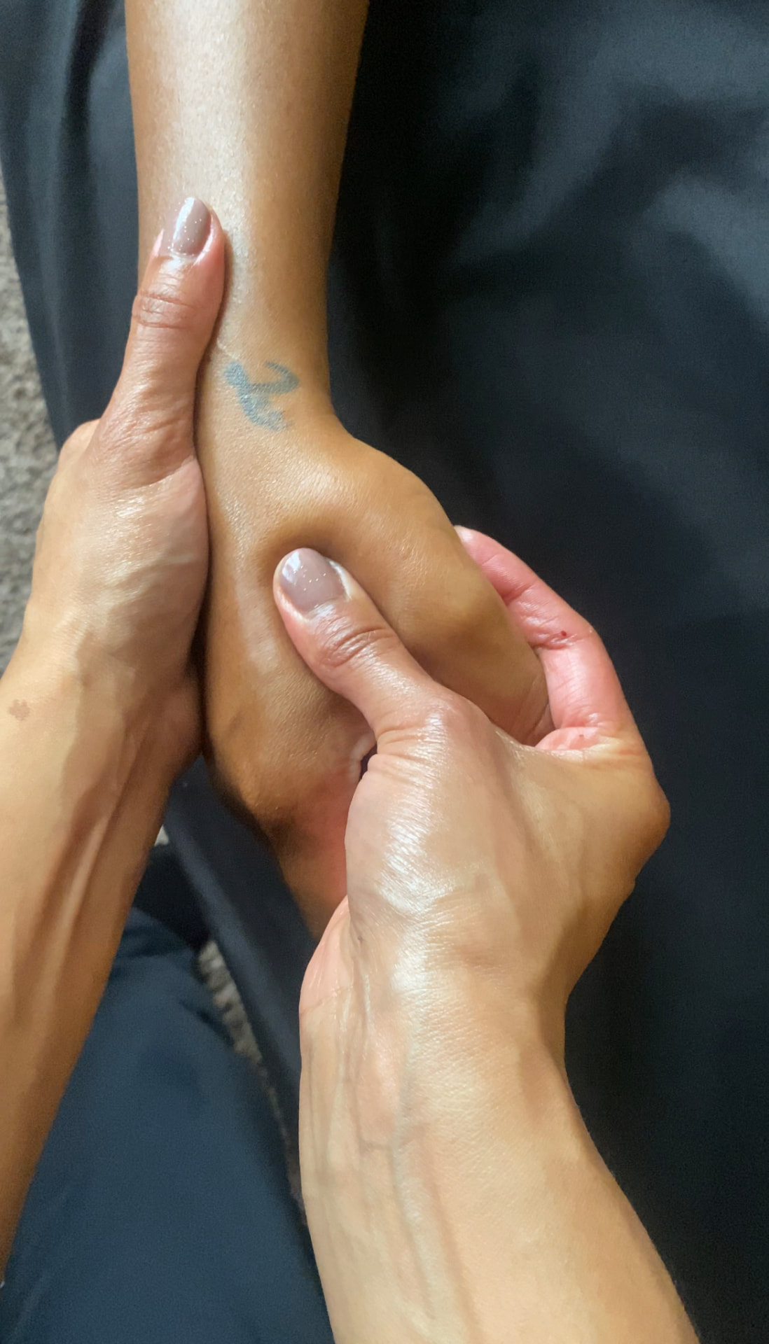 Therapist's hands working along a client's lower leg